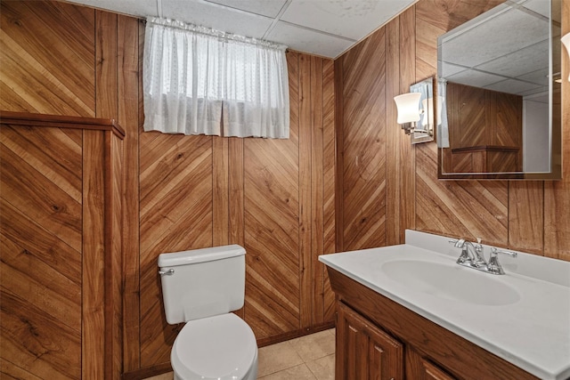 bathroom featuring a paneled ceiling, wood walls, and vanity