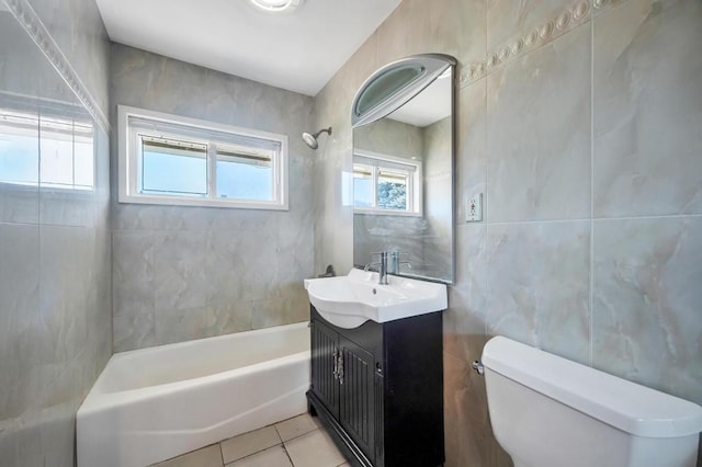 full bath with toilet, tile patterned flooring, vanity, shower / washtub combination, and tile walls