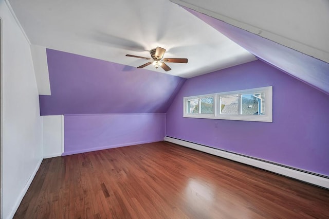 additional living space featuring a baseboard heating unit, vaulted ceiling, wood finished floors, and baseboards