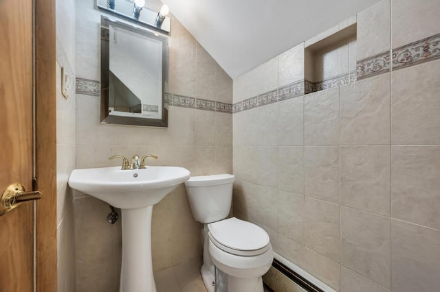 half bath with lofted ceiling, toilet, and tile walls