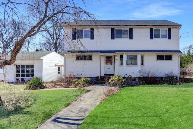 view of front of property with entry steps, an outbuilding, and a front lawn