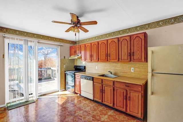 kitchen with black electric range, freestanding refrigerator, a sink, under cabinet range hood, and dishwashing machine