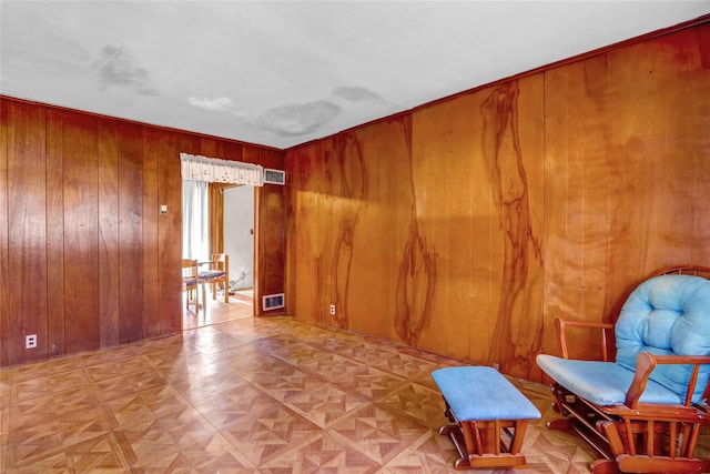 living area featuring visible vents and wooden walls