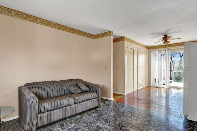 living room with a ceiling fan and baseboards