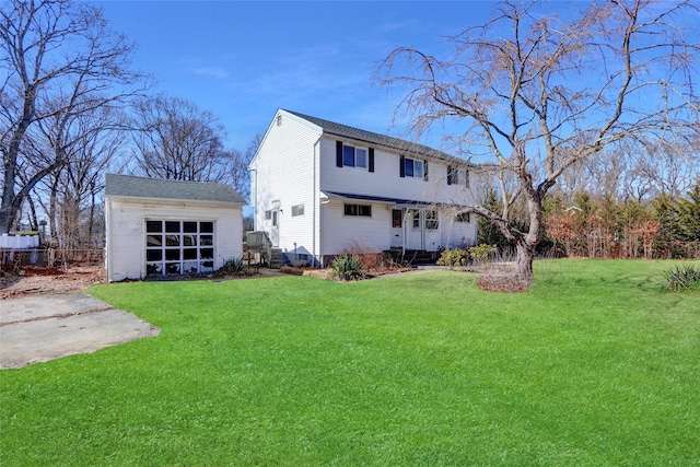 back of house featuring a yard and an outdoor structure