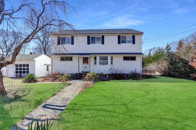 view of front of house with a front yard, an outdoor structure, and entry steps