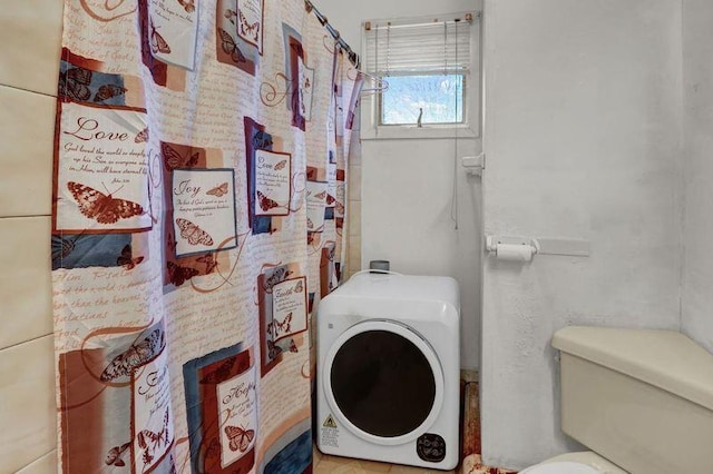 bathroom with washer / clothes dryer and toilet