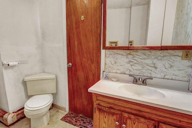 bathroom with toilet, tile patterned flooring, backsplash, and vanity