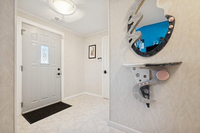 foyer with baseboards, marble finish floor, visible vents, and crown molding