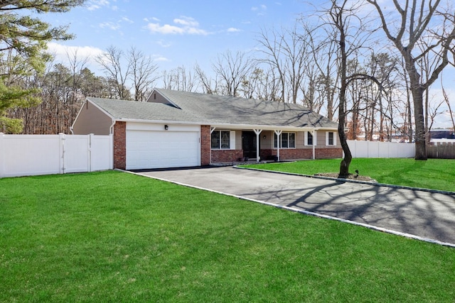 single story home featuring aphalt driveway, a front lawn, fence, and brick siding