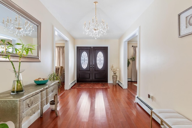 foyer entrance featuring a chandelier, a baseboard radiator, a baseboard heating unit, and wood finished floors