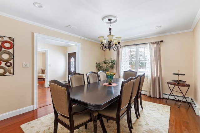 dining room featuring an inviting chandelier, baseboards, dark wood finished floors, and crown molding