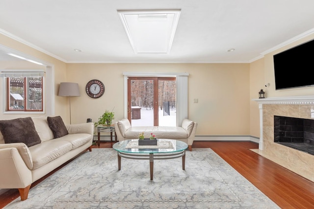 living room with a baseboard radiator, crown molding, wood finished floors, and a tile fireplace