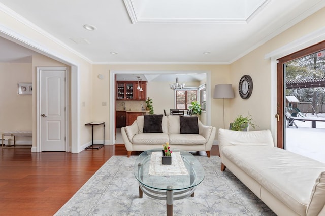 living area with dark wood finished floors, recessed lighting, ornamental molding, a chandelier, and baseboards