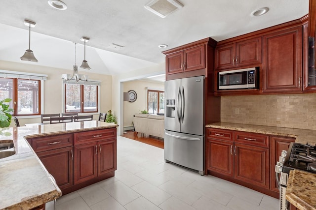 kitchen with stainless steel appliances, hanging light fixtures, light countertops, and dark brown cabinets