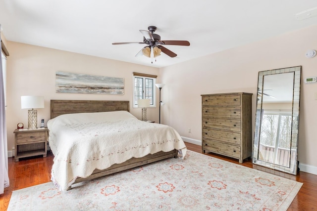 bedroom featuring dark wood-style floors, baseboards, and a ceiling fan