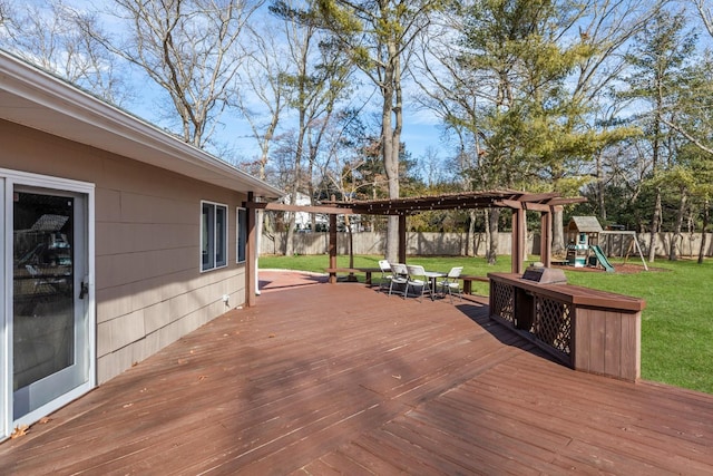 deck featuring a yard, outdoor dining area, a playground, and a fenced backyard