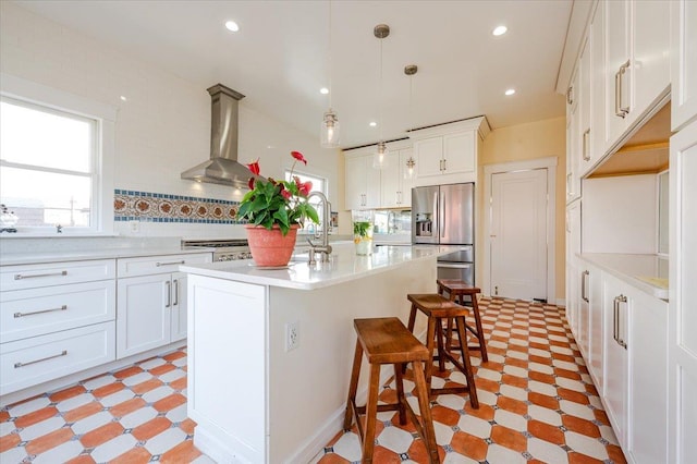 kitchen featuring stainless steel fridge with ice dispenser, a breakfast bar area, extractor fan, light countertops, and light floors