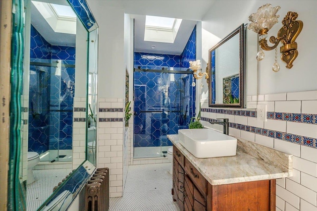 full bathroom with toilet, a skylight, radiator heating unit, and tile walls