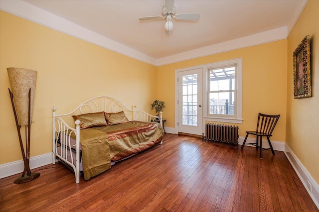 bedroom featuring radiator, a ceiling fan, baseboards, and hardwood / wood-style floors