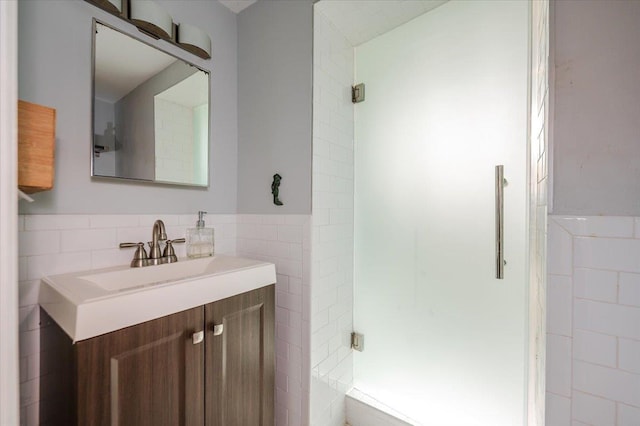 full bathroom with wainscoting, a shower stall, tile walls, and vanity