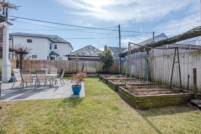 view of yard featuring a patio, a fenced backyard, and a garden