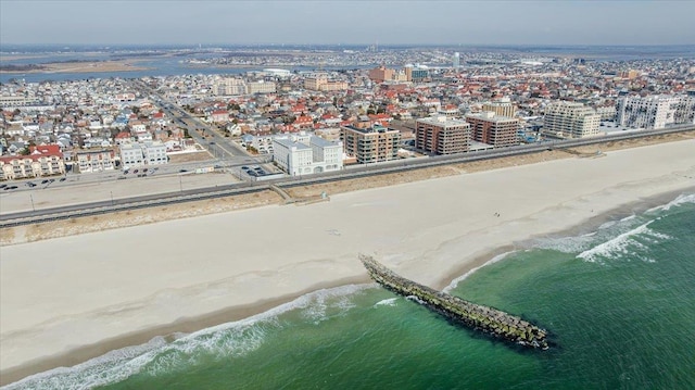 aerial view featuring a water view, a view of the beach, and a city view