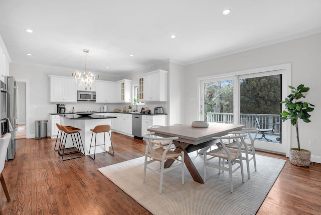 dining room with recessed lighting, dark wood-type flooring, baseboards, ornamental molding, and an inviting chandelier