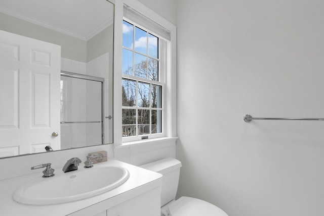 bathroom featuring an enclosed shower, ornamental molding, vanity, and toilet