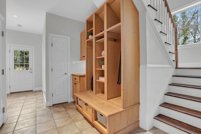 mudroom featuring a wealth of natural light, a wainscoted wall, and light tile patterned floors