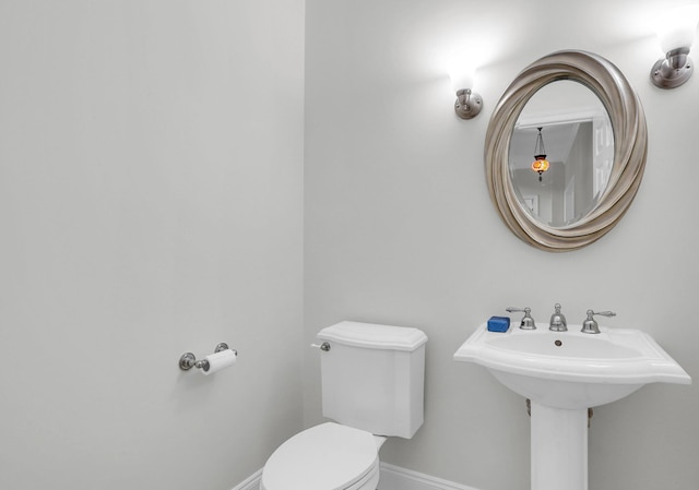 bathroom with toilet and baseboards