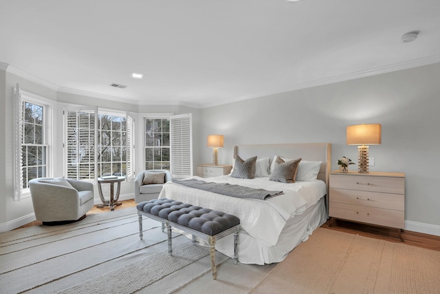 bedroom featuring ornamental molding, multiple windows, wood finished floors, and visible vents