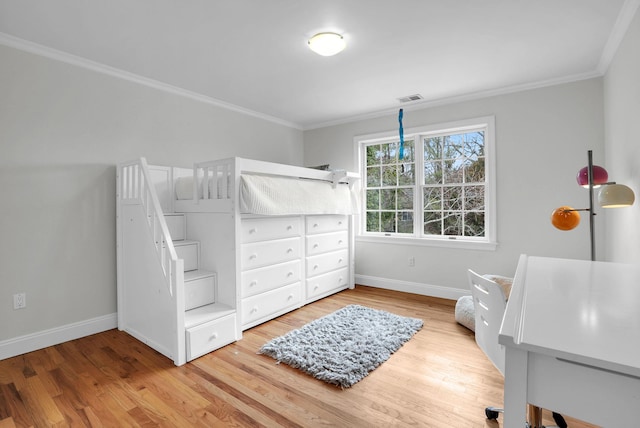 bedroom featuring baseboards, visible vents, wood finished floors, and ornamental molding