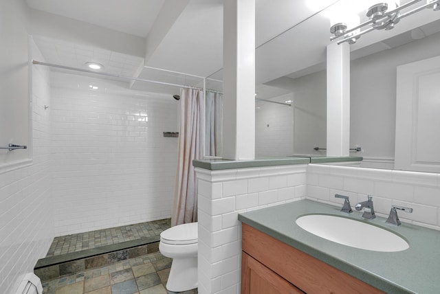 bathroom with toilet, a baseboard heating unit, vanity, tile walls, and a tile shower