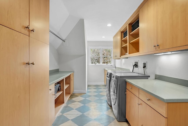 laundry room featuring cabinet space, baseboards, light floors, washing machine and dryer, and a sink