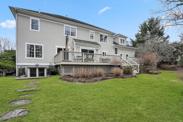 back of house featuring a deck, a lawn, and an attached garage