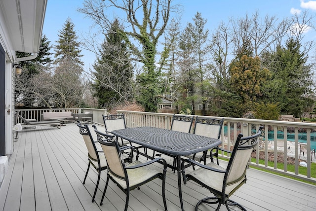 deck featuring outdoor dining space and an outdoor pool