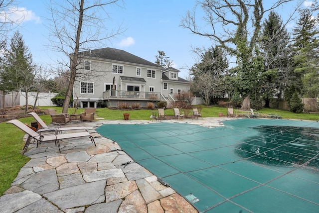 view of swimming pool featuring a fenced backyard, a yard, a wooden deck, a fenced in pool, and a patio area