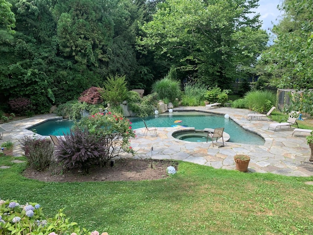 outdoor pool featuring a patio, a lawn, and an in ground hot tub