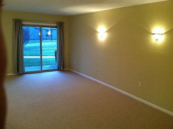 unfurnished room with carpet and baseboards