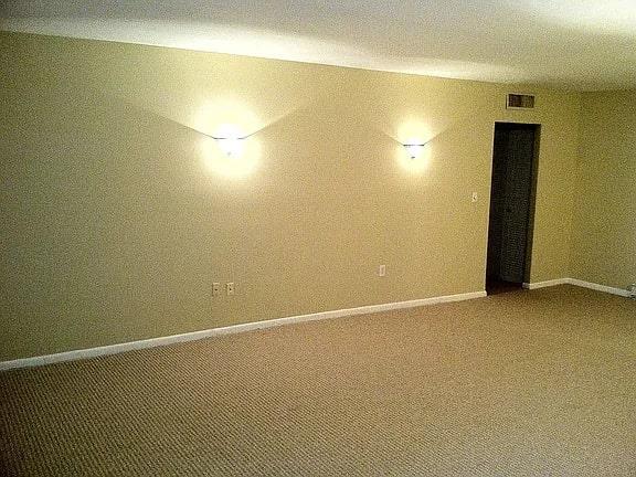 below grade area featuring carpet flooring, visible vents, and baseboards