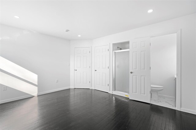 unfurnished bedroom featuring baseboards, ensuite bathroom, dark wood finished floors, and recessed lighting