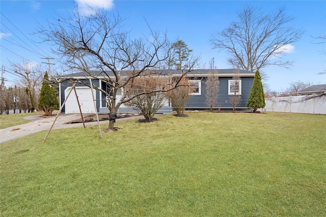 view of front facade featuring a garage, fence, concrete driveway, and a front yard