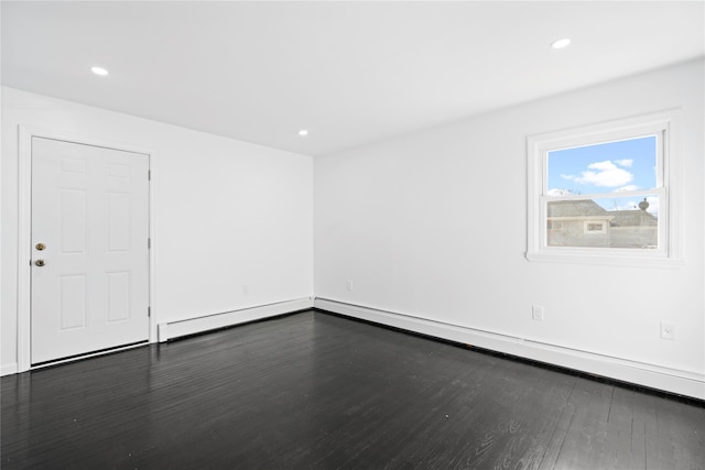 empty room with a baseboard heating unit, dark wood finished floors, and recessed lighting