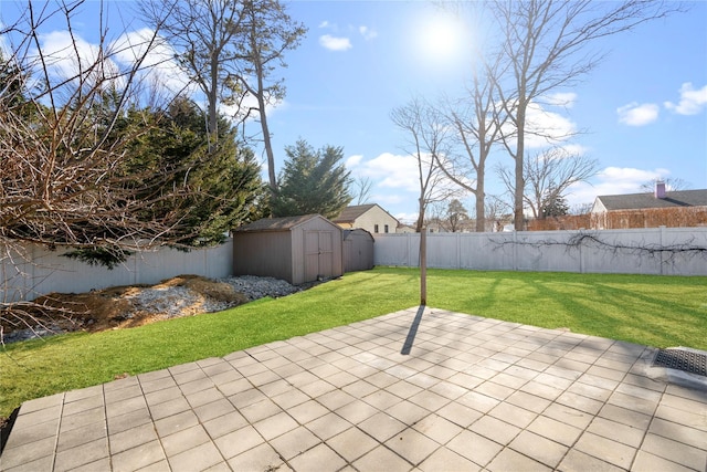 view of patio / terrace with a shed, a fenced backyard, and an outbuilding