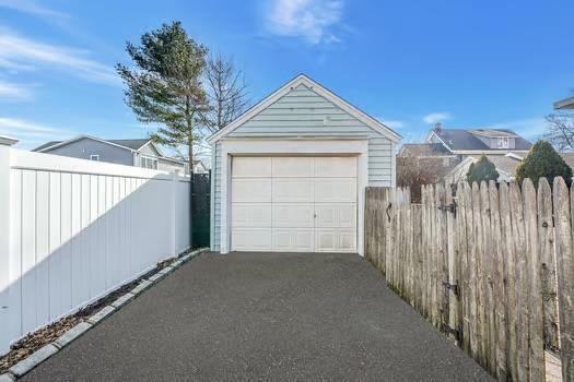 detached garage with driveway and fence