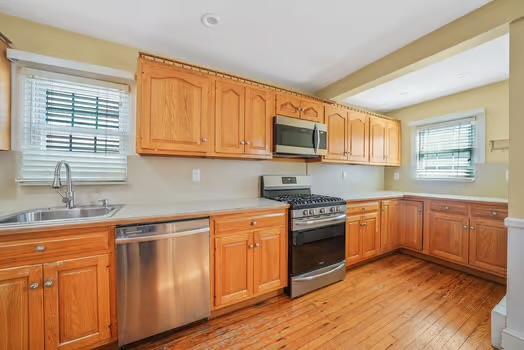 kitchen featuring appliances with stainless steel finishes, light countertops, and a sink