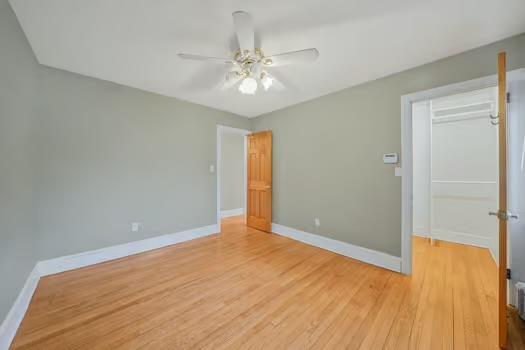 unfurnished bedroom featuring a ceiling fan, a closet, light wood finished floors, and baseboards