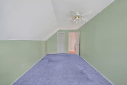 bonus room featuring lofted ceiling, carpet flooring, a ceiling fan, and baseboards