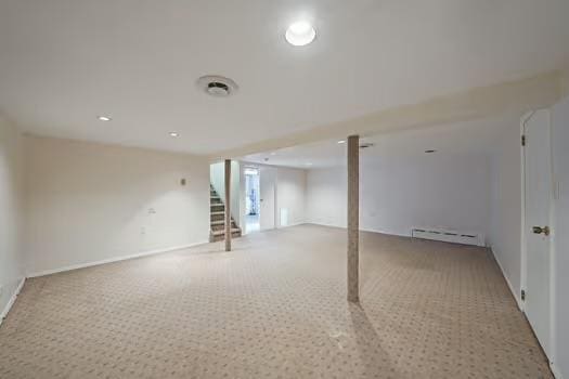 below grade area featuring light carpet, a baseboard radiator, and stairway